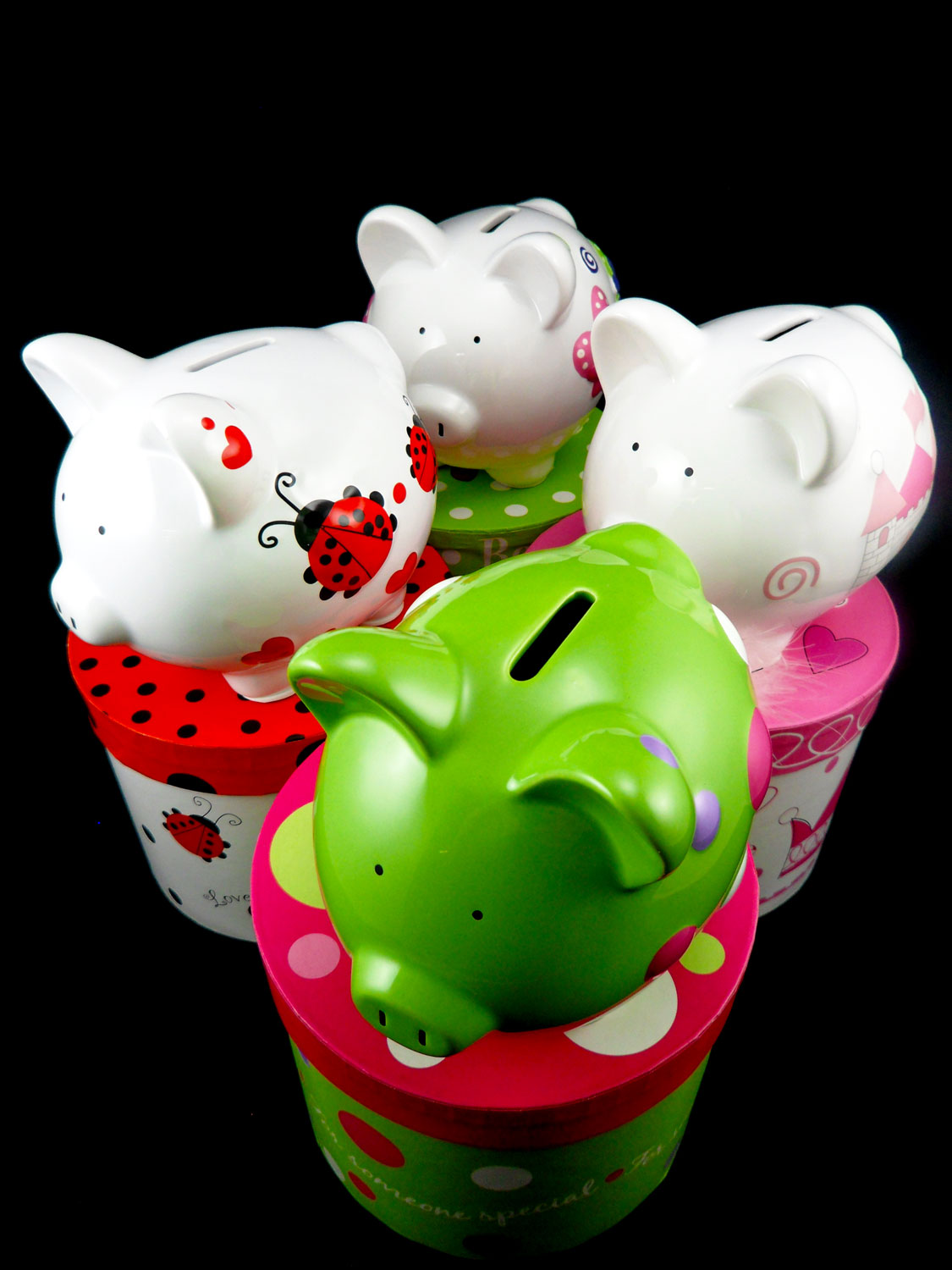 Four personalized piggy banks for girls: Green with polka dots, painted with pink castle, painted with ladybugs, and painted with butterflies | OrnamentShop.com