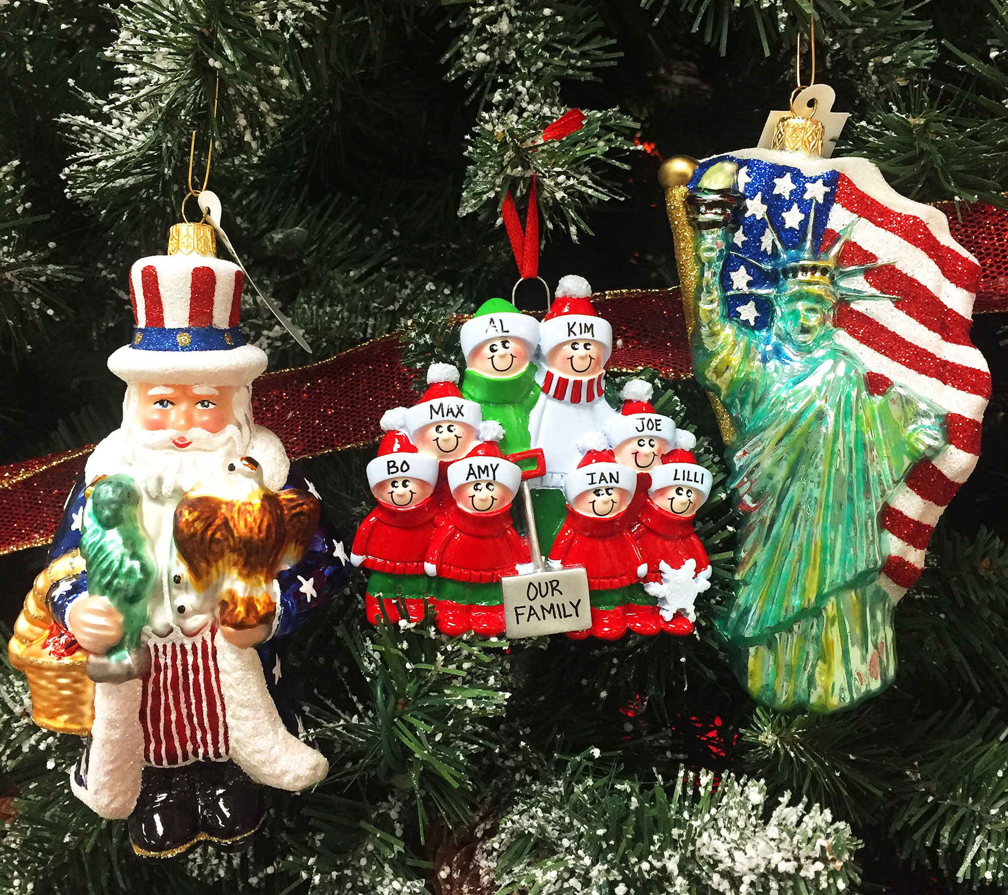 An American Santa ornament holds a mini statue of liberty and bald eagle, a family ornament contains 8 family members all personalzied with names, and a statue of liberty ornament with an American flag | OrnamentShop.com