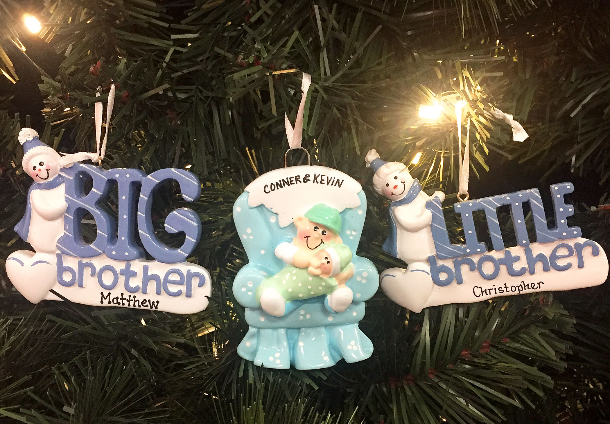 Two snowman ornaments for a big brother and little brother, and an ornament with a big brother holding his younger sibling in a green arm chair | OrnamentShop.com