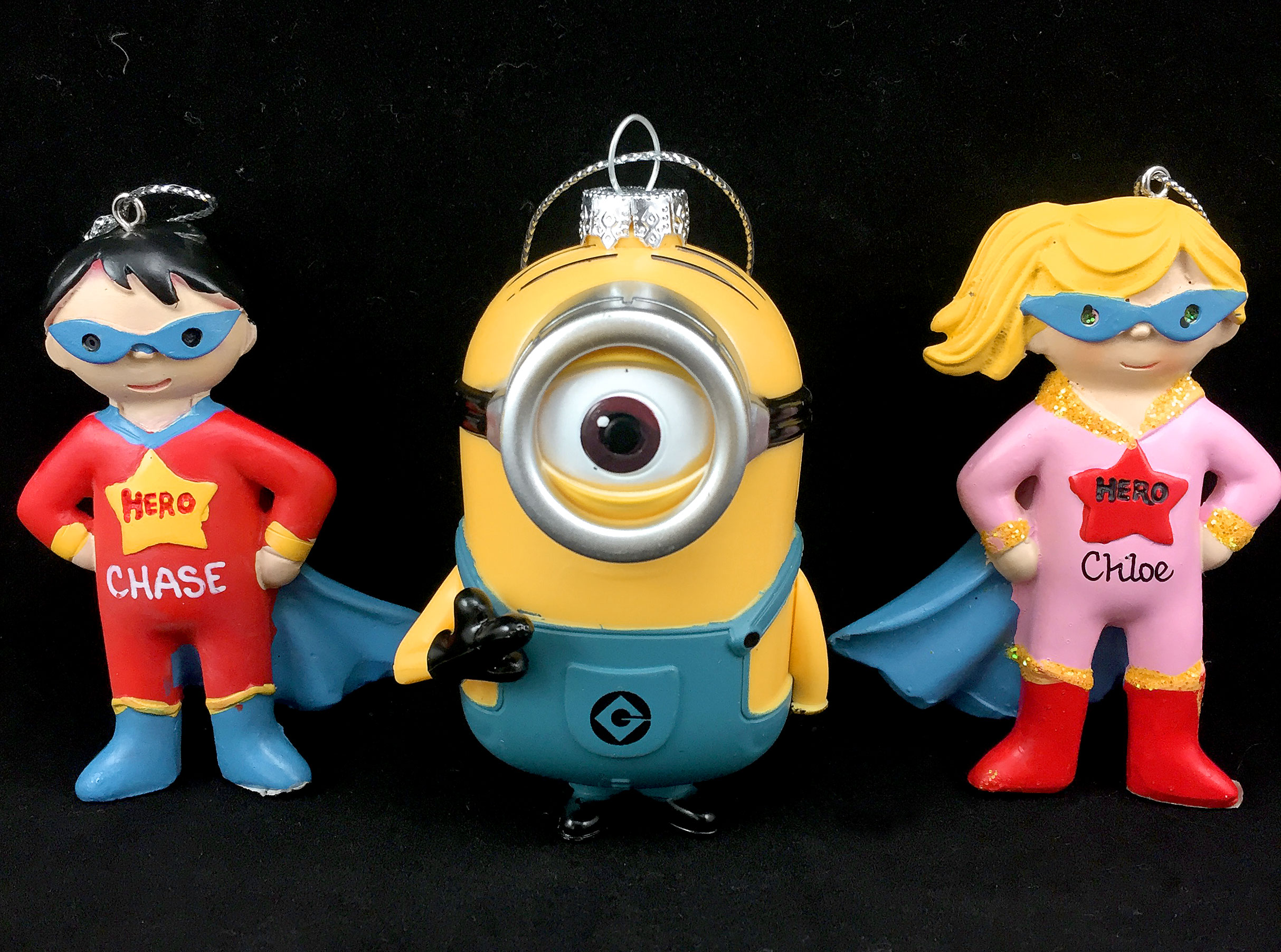 Two superhero kid ornaments wearing capes and masks, and a one-eyed minion ornament | OrnamentShop
