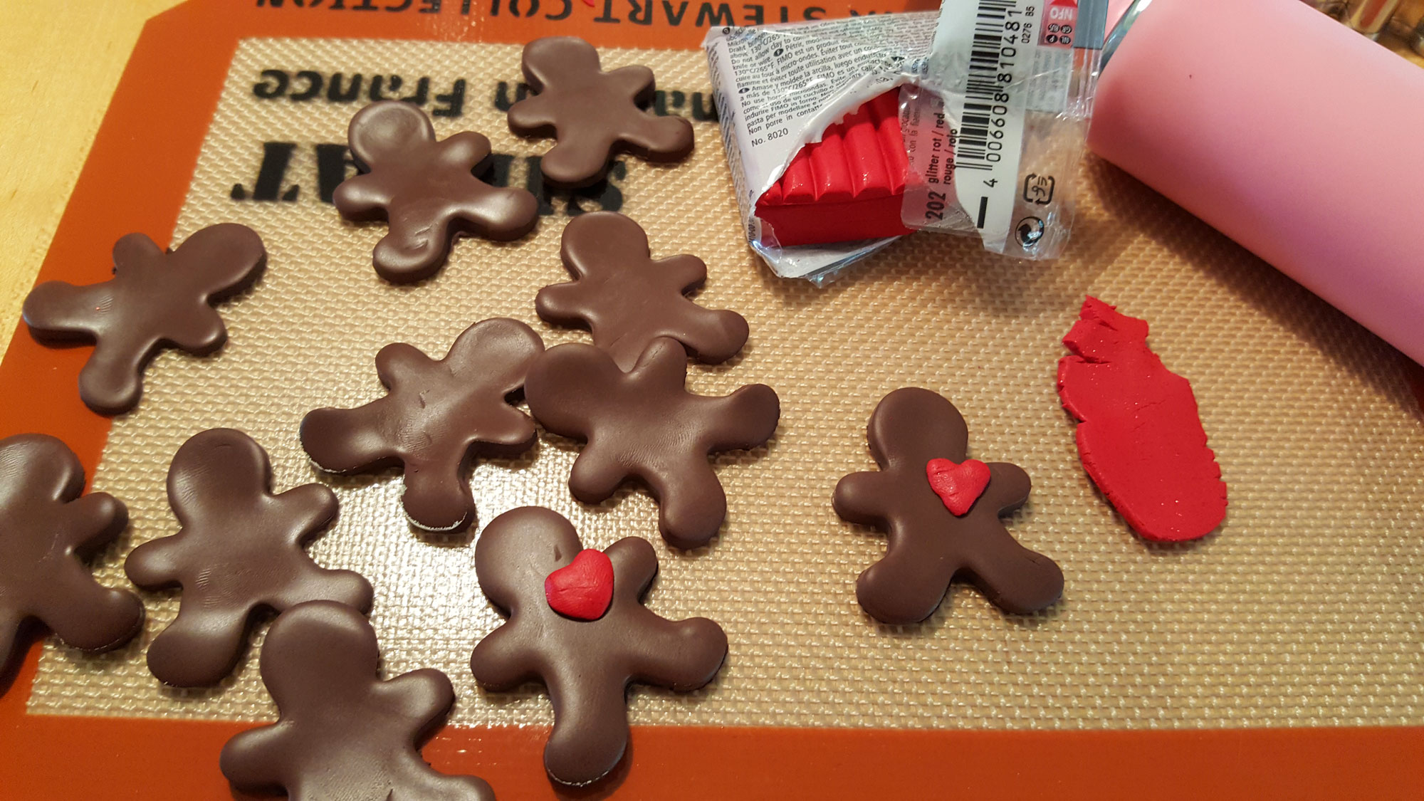 Step 3 is to use the red clay to place little hearts on your gingerbread people | OrnamentShop.com