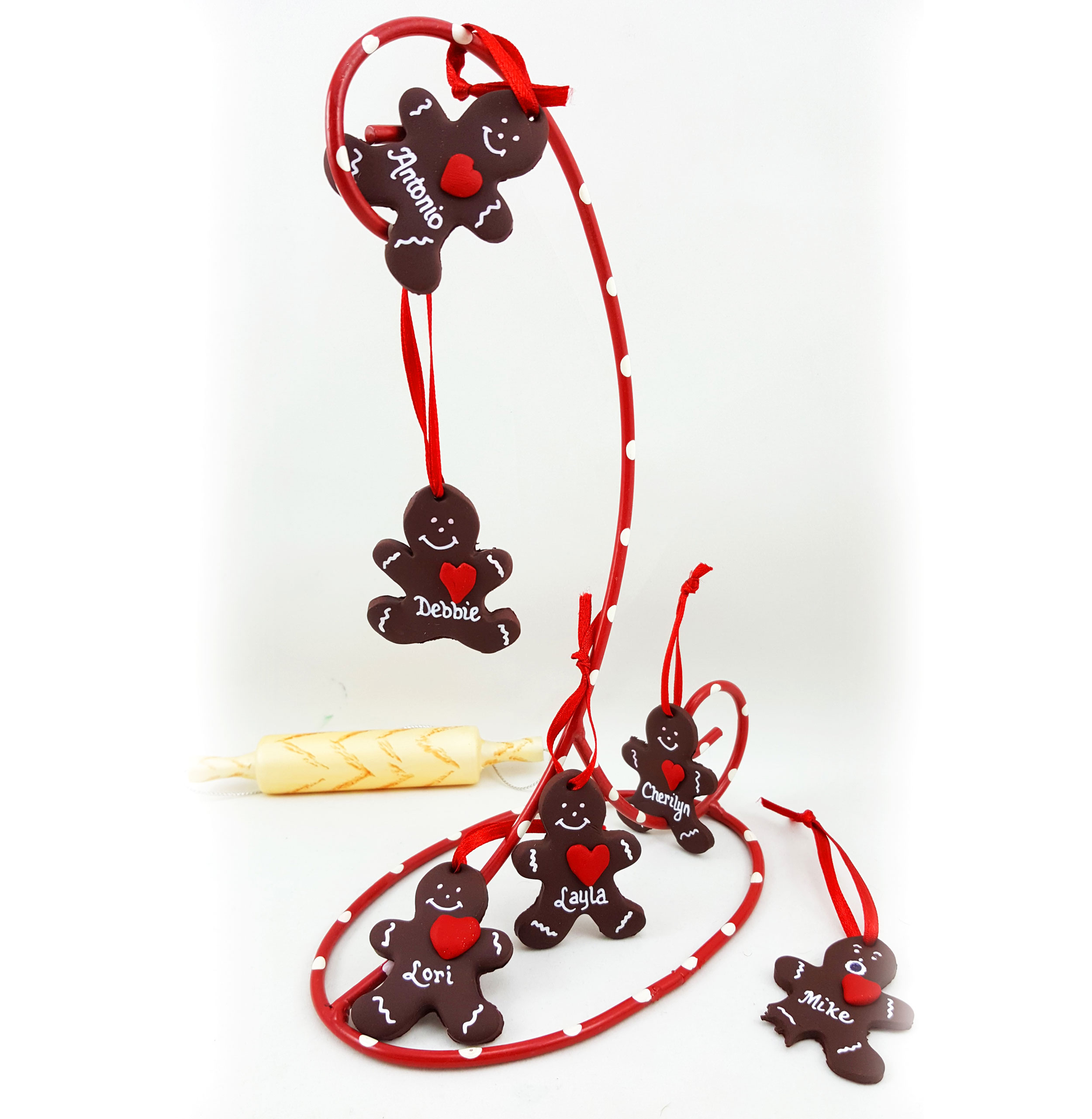 A small army of little gingerbread men hang from a candy cane ornament display hanger, with a variety of cute expressions such as one with a leg that was bitten | OrnamentShop.com