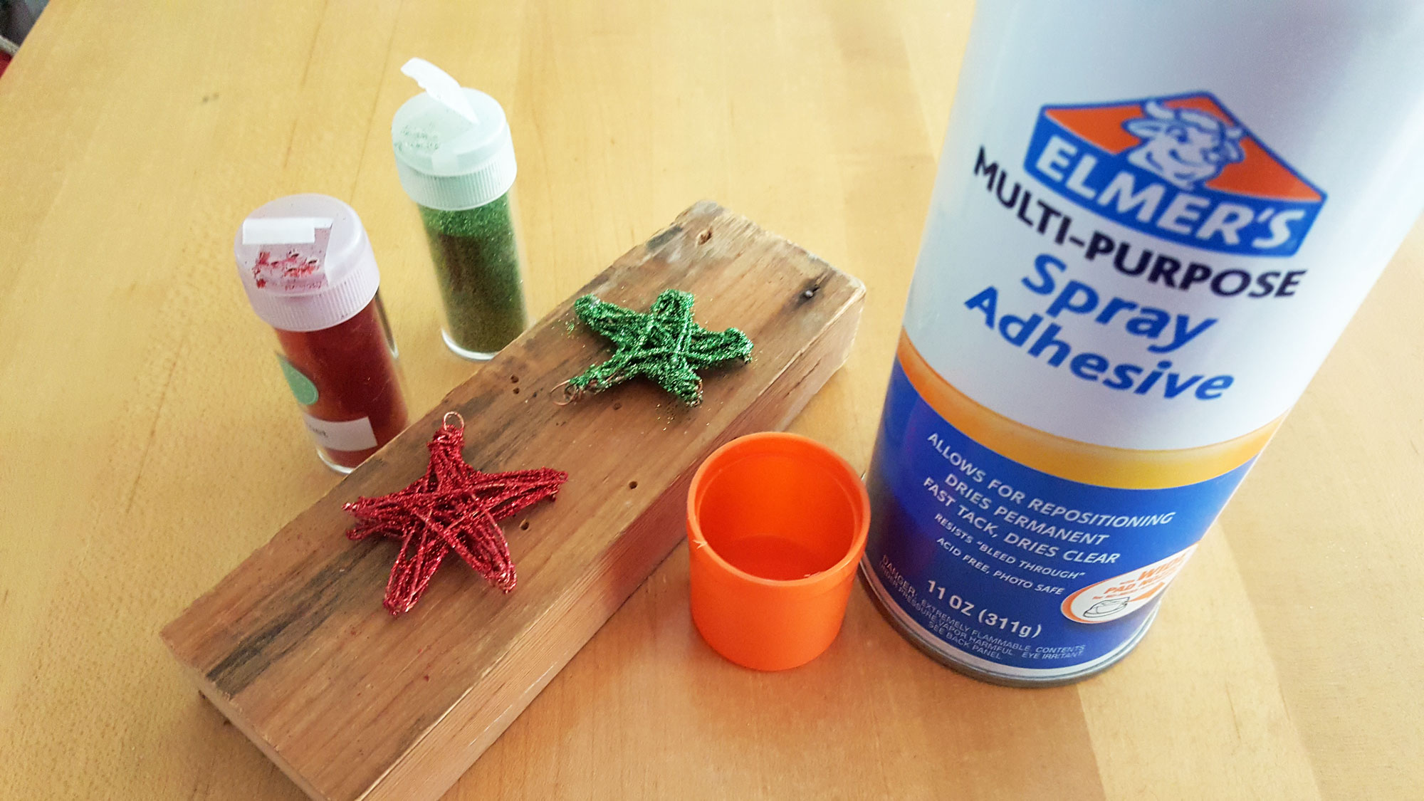 Step 5 is to use spray adhesive to coat the stars, then shake glitter all over them | OrnamentShop.com