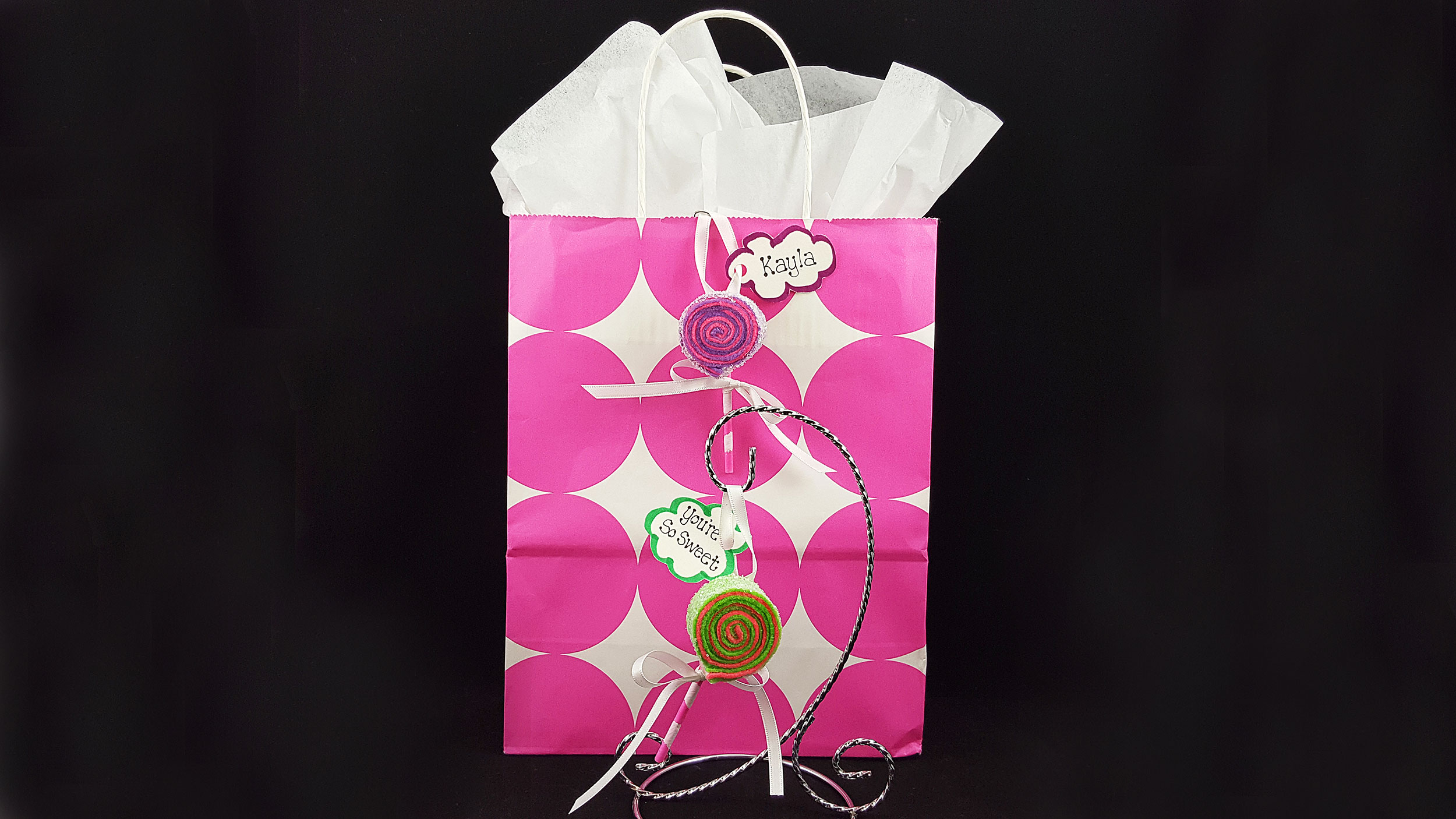 A finished DIY lollipop ornament on the front of a birthday girl's gift bag. | OrnamentShop.com
