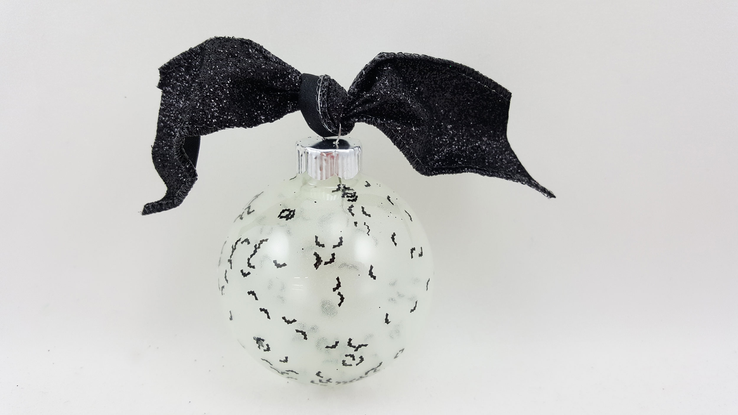 A Halloween glow in the dark ornament made with glow in the dark nail polish and plastic confetti. | OrnamentShop.com
