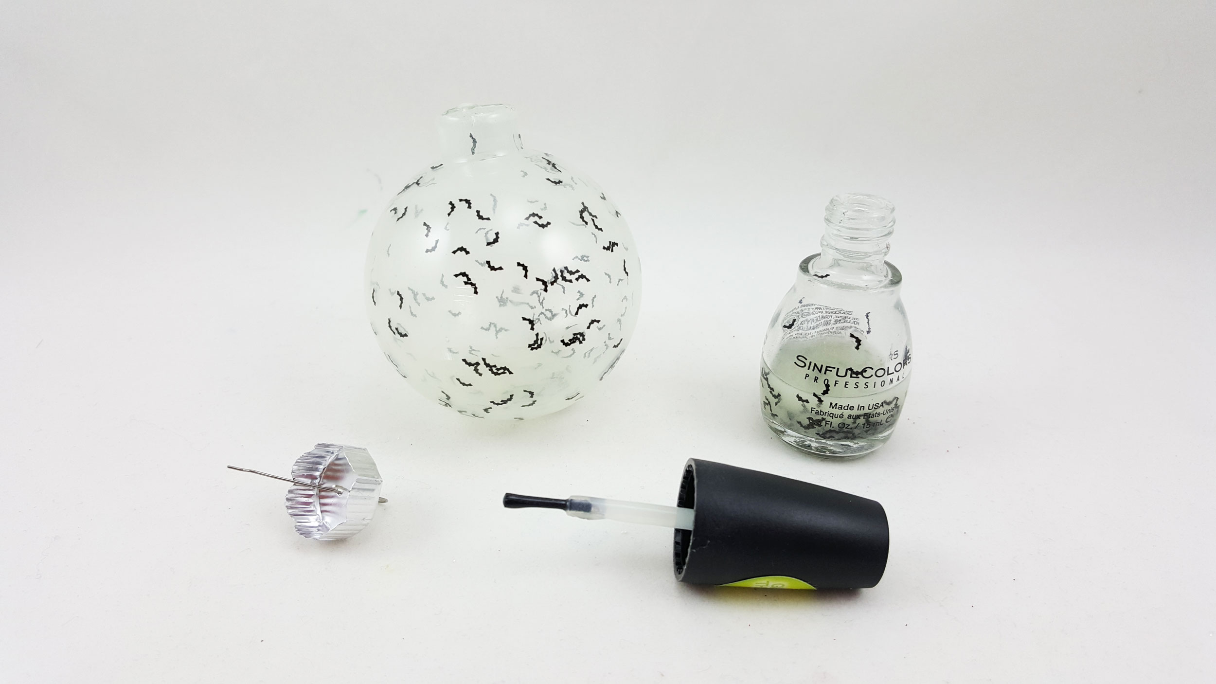 Step 1 is to carefully remove the cap from the clear glass ball ornament and sprinkle the confetti inside, then pour your glow in the dark paint or nail polish inside, swirling it around. | OrnamentShop.com
