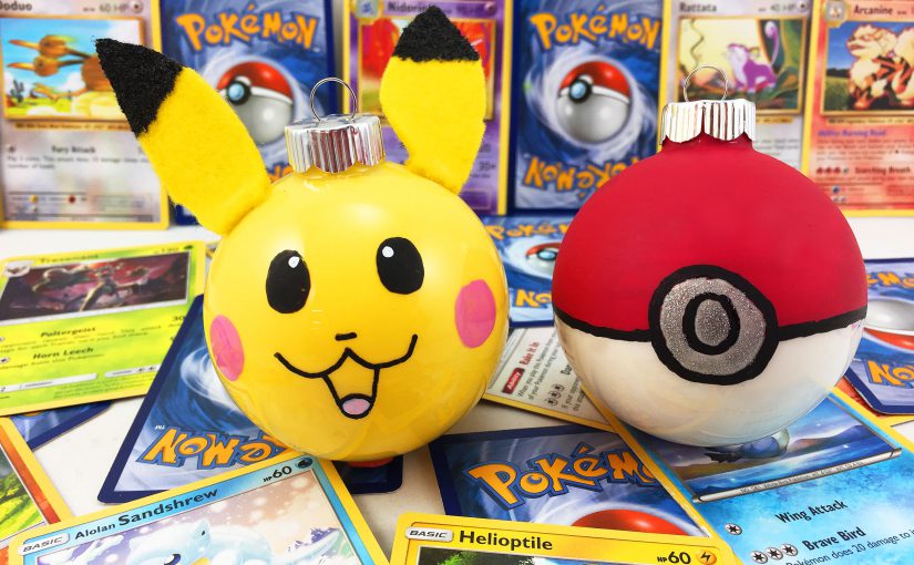 Two DIY Pokemon ornaments are surrounded by a Pokemon fan's trading card collection. | OrnamentShop.com