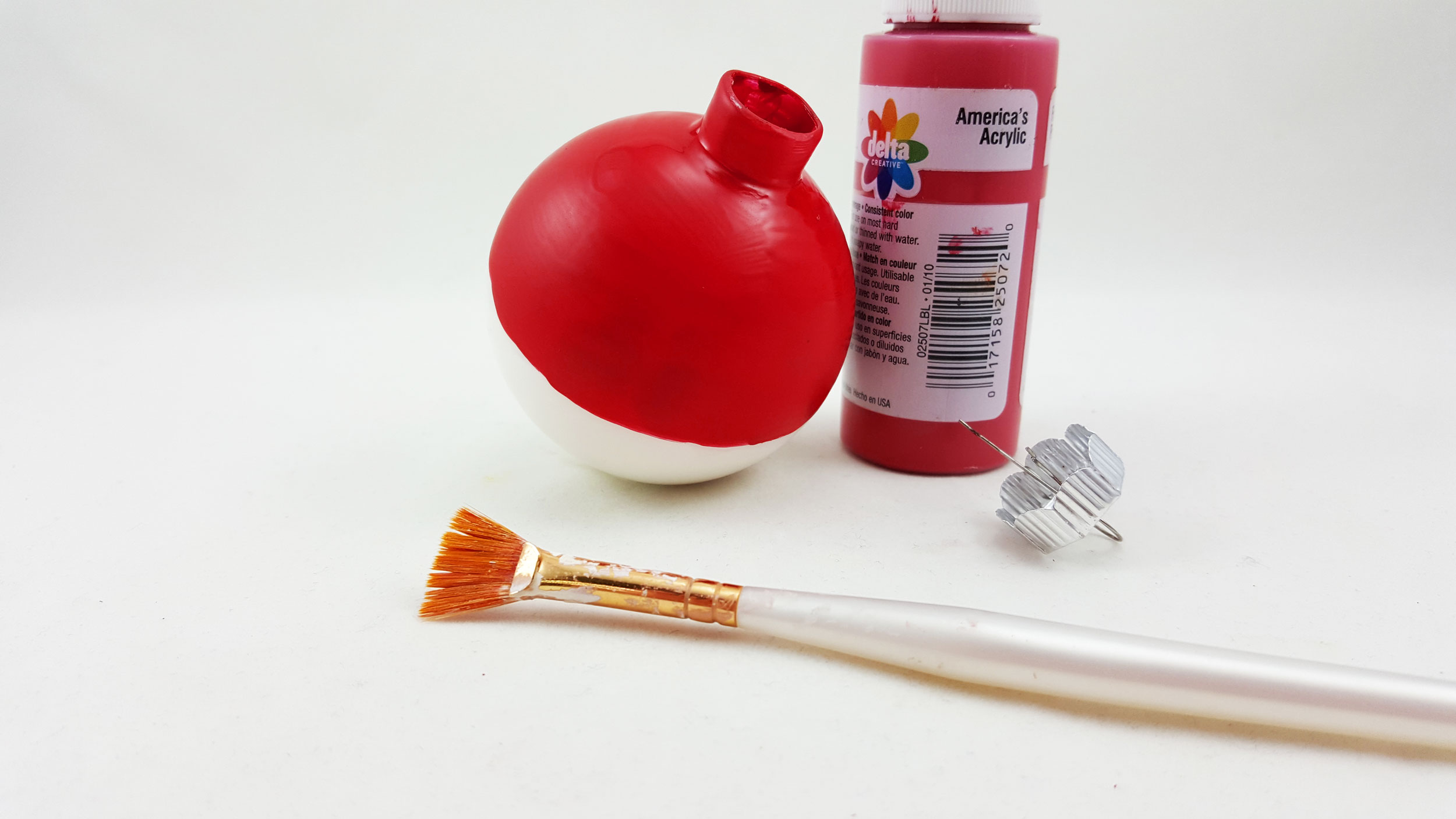 The second step to make a Pokeball ornament is to paint the outside of the top half of the ball red. | OrnamentShop.com
