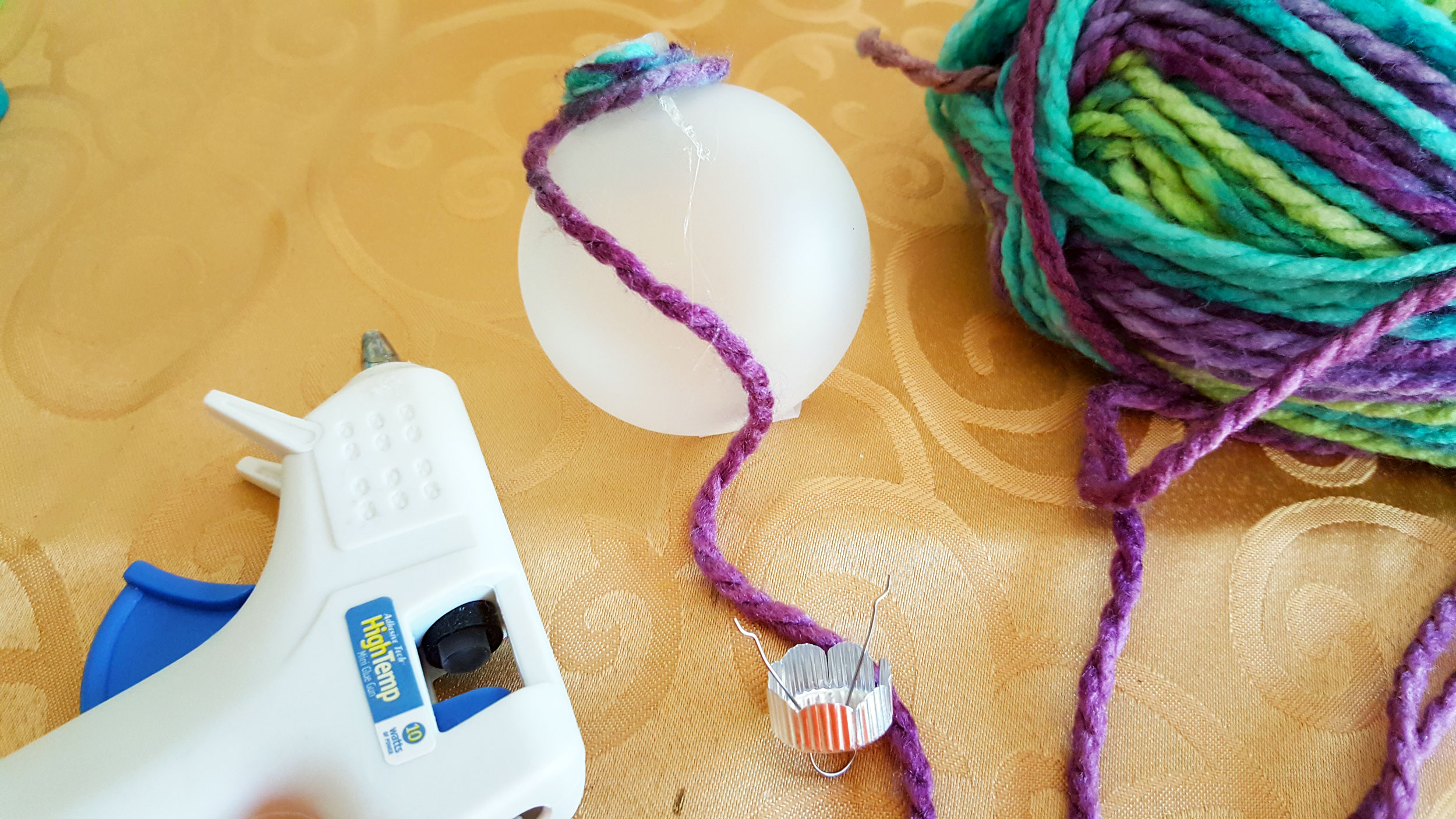 Step 2 is to carefully wrap the class ball with your first choice in yarn and use hot glue to secure it. | OrnamentShop.com