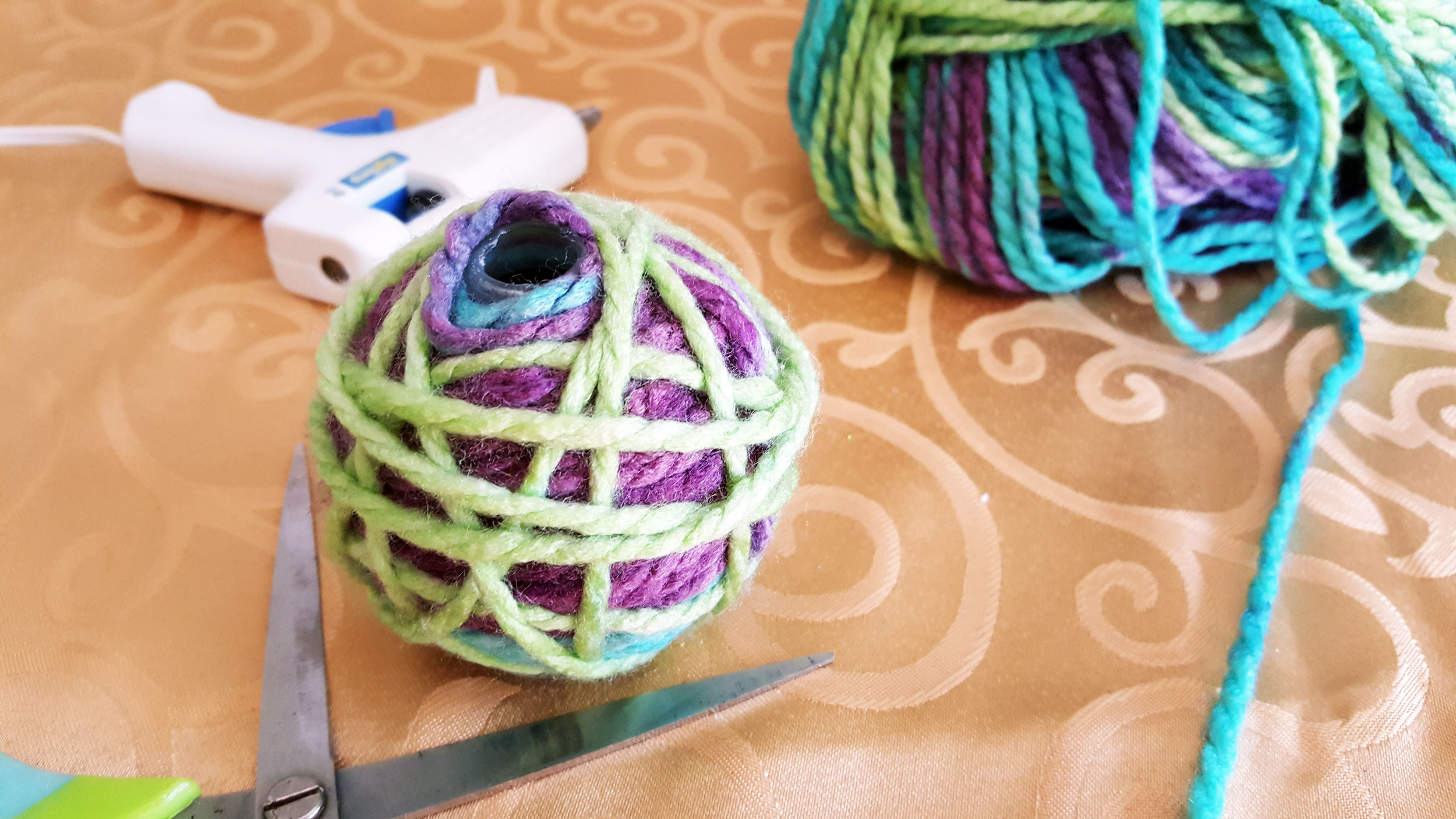 Step 4 is to use a second color yarn and wrap the ornament the ornament more sparingly in a different direction. | OrnamentShop.com