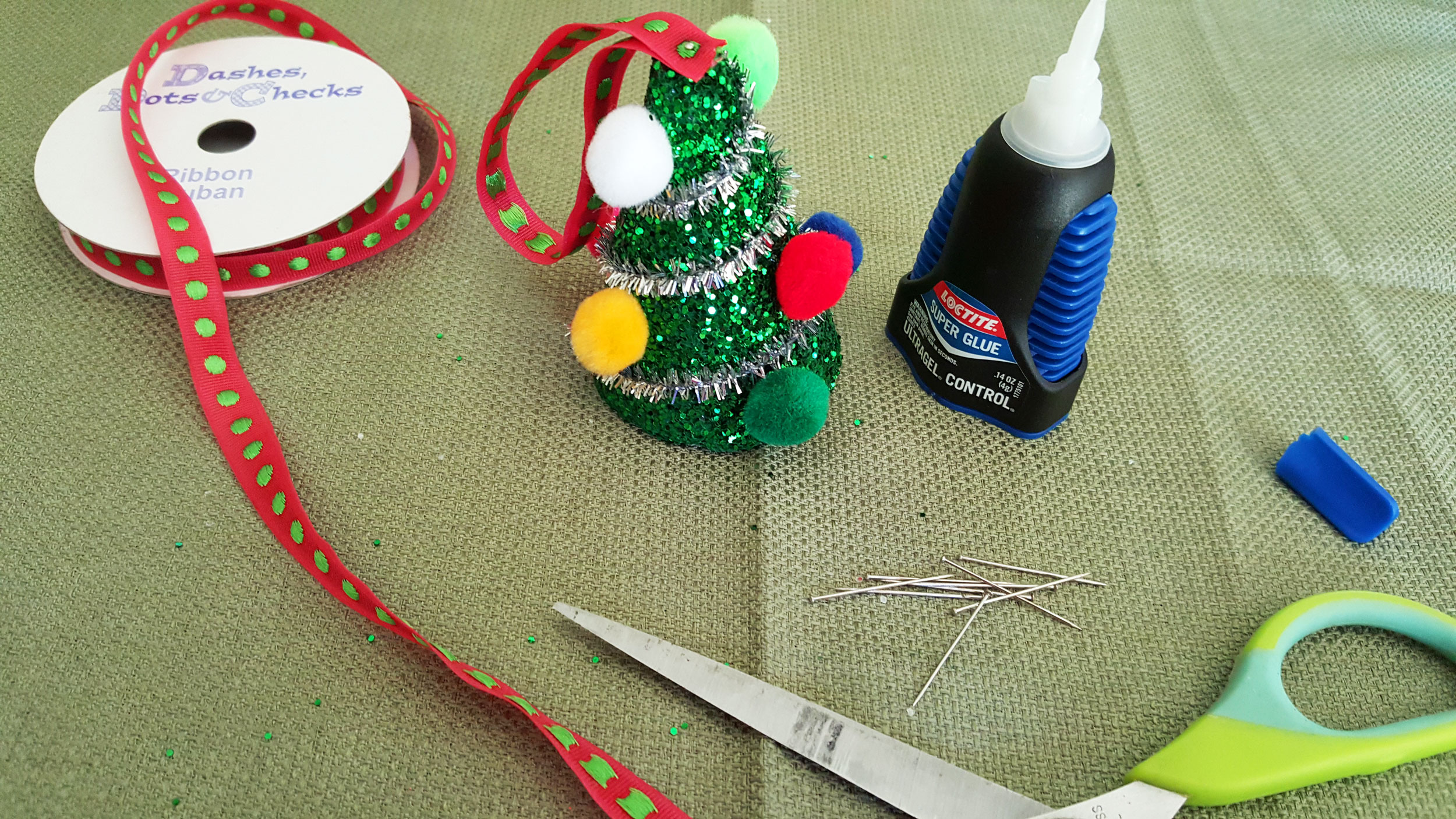 Step 5 is to glue a strand of ribbon together in a loop an decorate it with drops of glitter glue. Pin the top of the Styrofoam through the ribbon so it can hang. | OrnamentShop.com