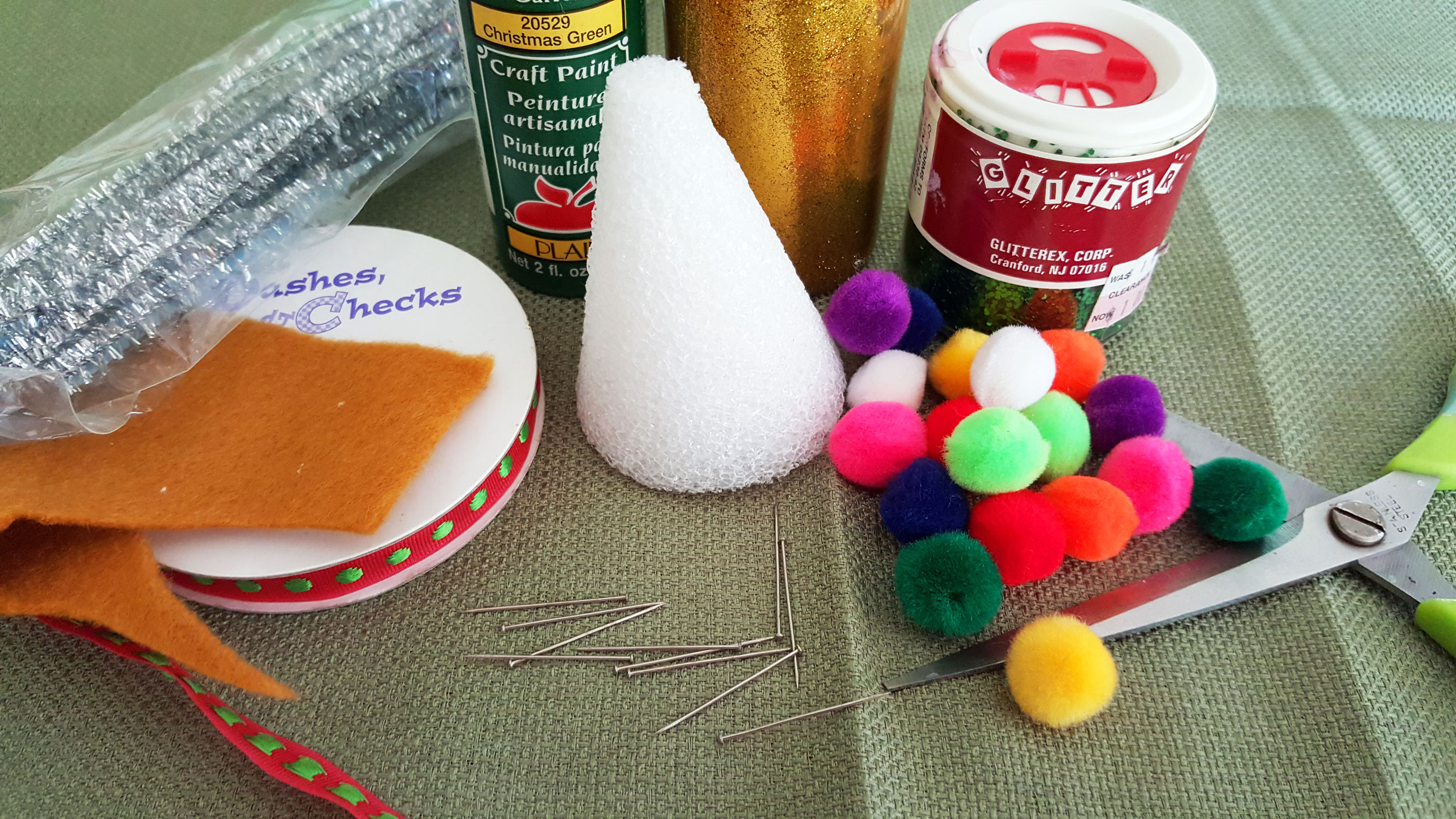 Supplies for a mini Christmas tree include a styrofoam cone, paint, glitter, pipe cleaners, glue, ribbon and pom poms. | OrnamentShop.com
