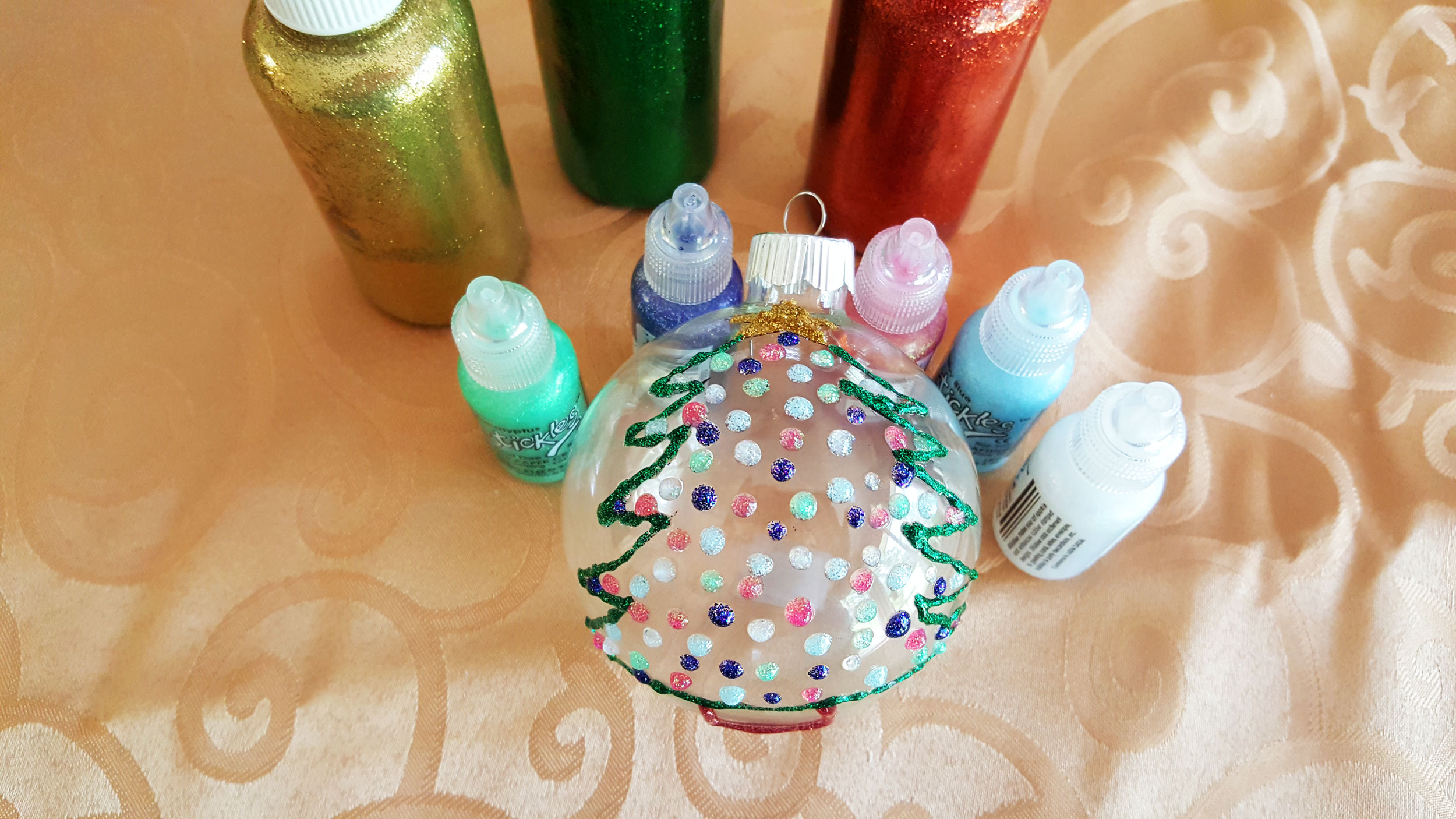 Step 2 is to paint the star and outline the rest of the tree and stump with glitter glue in different colors. Wait to let it dry. | OrnamentShop.com