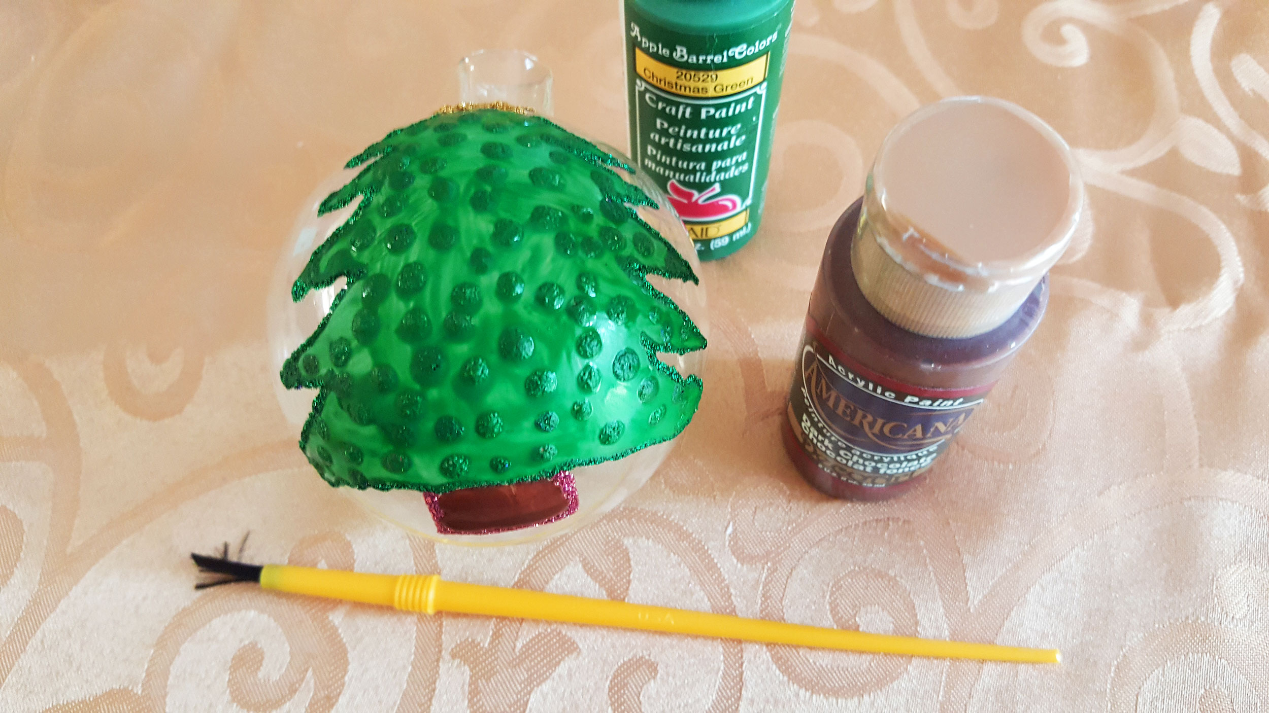 Step 3 is to use green paint to paint over your glitter glue outlines as a back drop so that the glitter is seen inside the ornament but not from the outside. | OrnamentShop.com