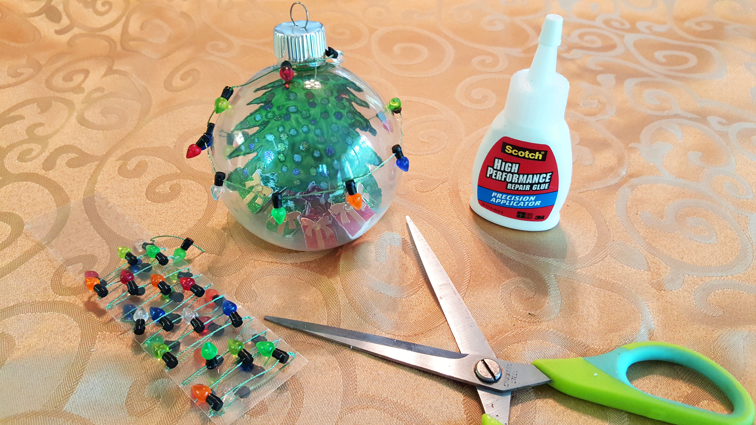 Step 6 is to glue the decorative Christmas lights to the circumference of the ball and use little dabs of glue on every couple lights. | OrnamentShop.com