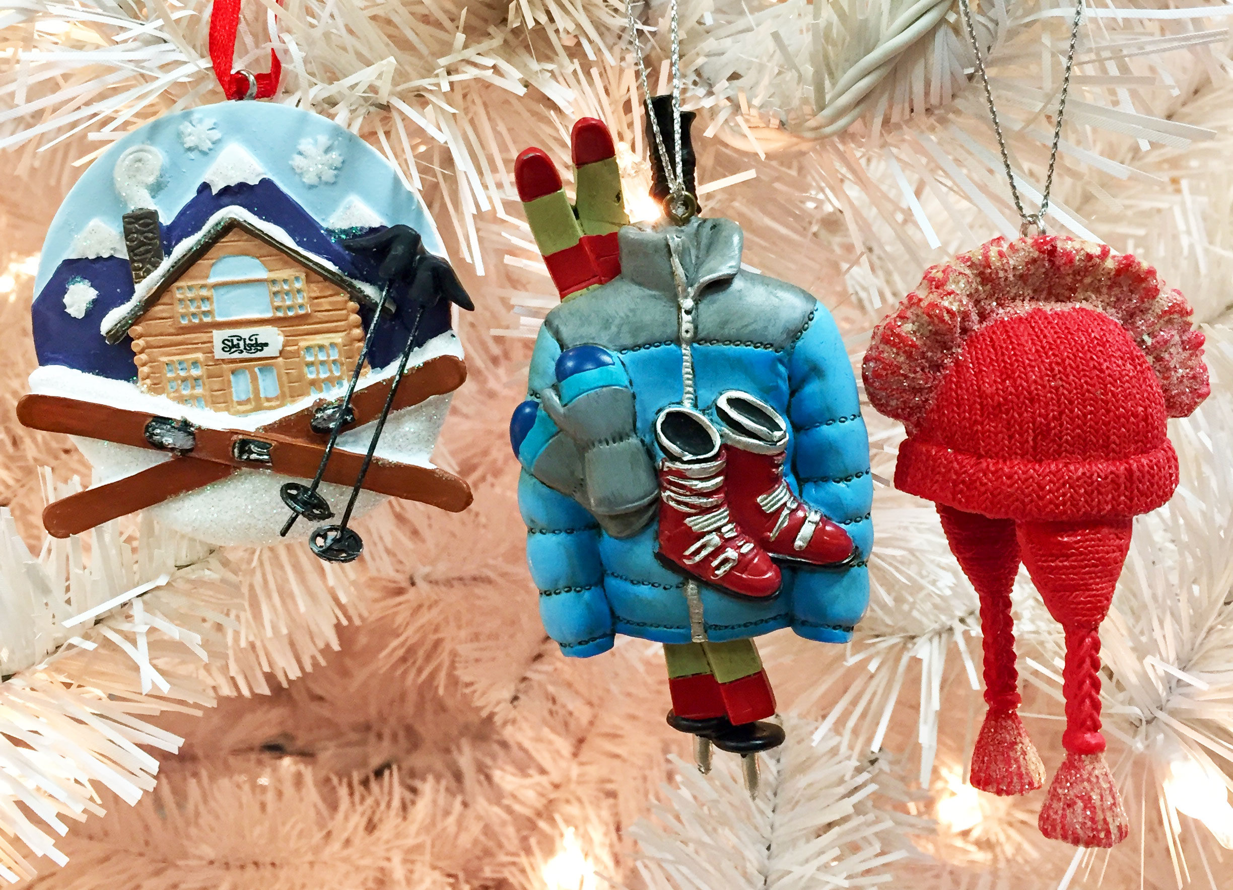 Three skiing ornaments including one for a ski lodge, one that has ski gear including a coat, scarf and boots, and a hat ornament that has a mohawk. | OrnamentShop.com