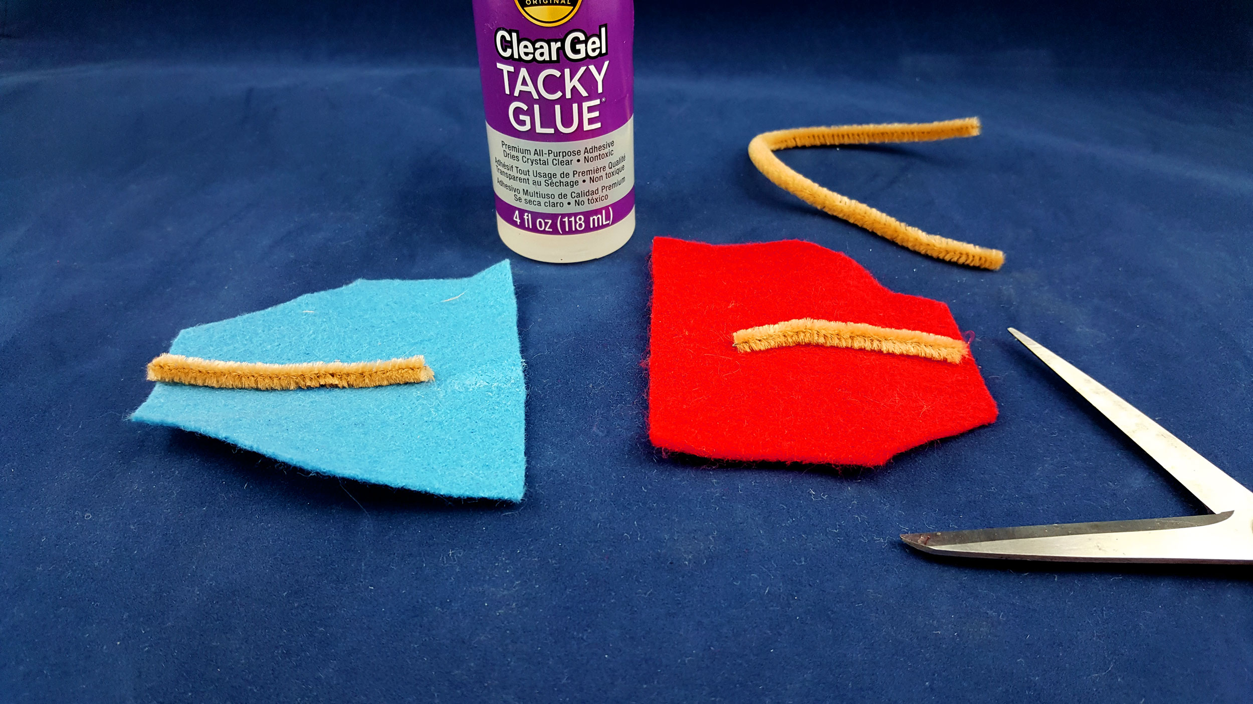 Cut a 2” piece of pipe cleaner and glue it to the top of the piece of felt, making sure that it goes to the edge in between the two cut corners. | OrnamentShop.com