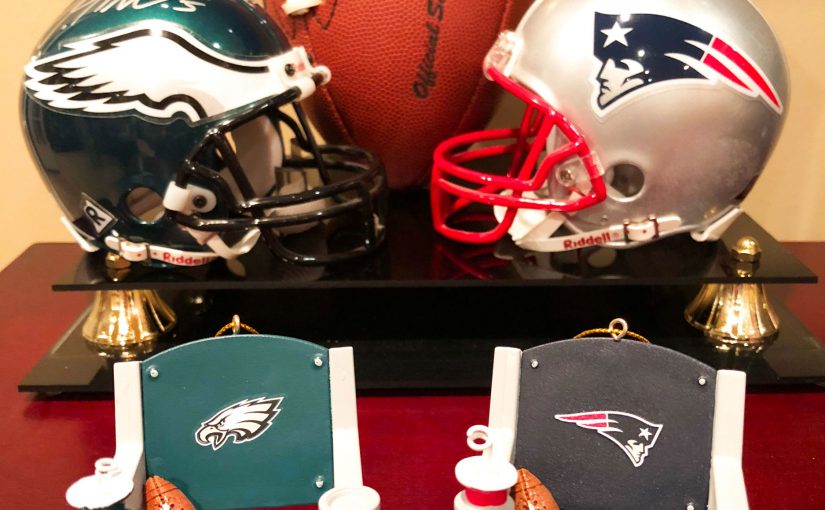 An Eagles helmet and Patriots helmet behind two ornaments for the Eagles and Patriots teams with stadium seats for each. | OrnamentShop.com