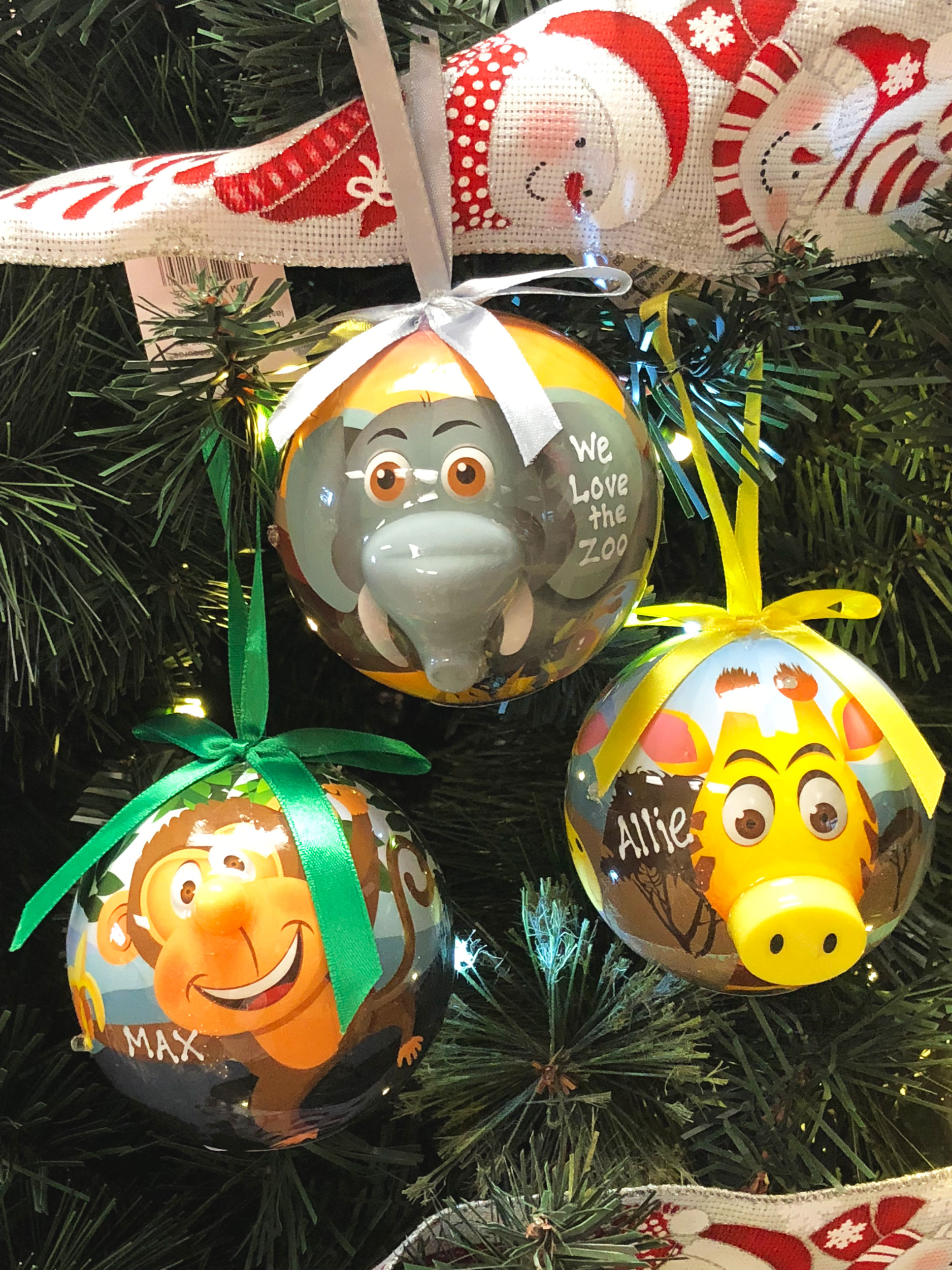 Three zoo animal ornaments on a tree with blinking noses - an elephant, giraffe and monkey. | OrnametnShop.com