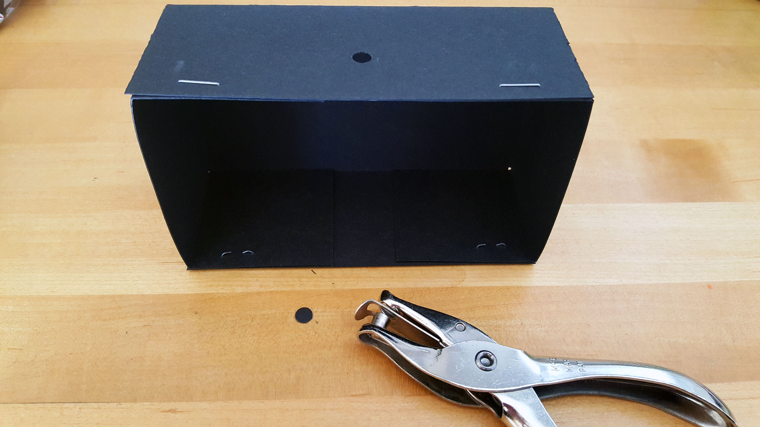 Step 1: Stand the box on its side and hole punch a hole on the top of the box. | OrnamentShop.com