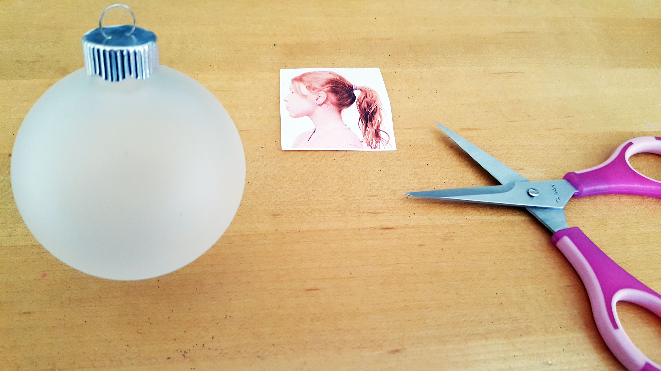 A frosted glass ball ornament next to a small pair of sewing scissors and a 2 inch tall cut out picture of a girl. | OrnamentShop.com