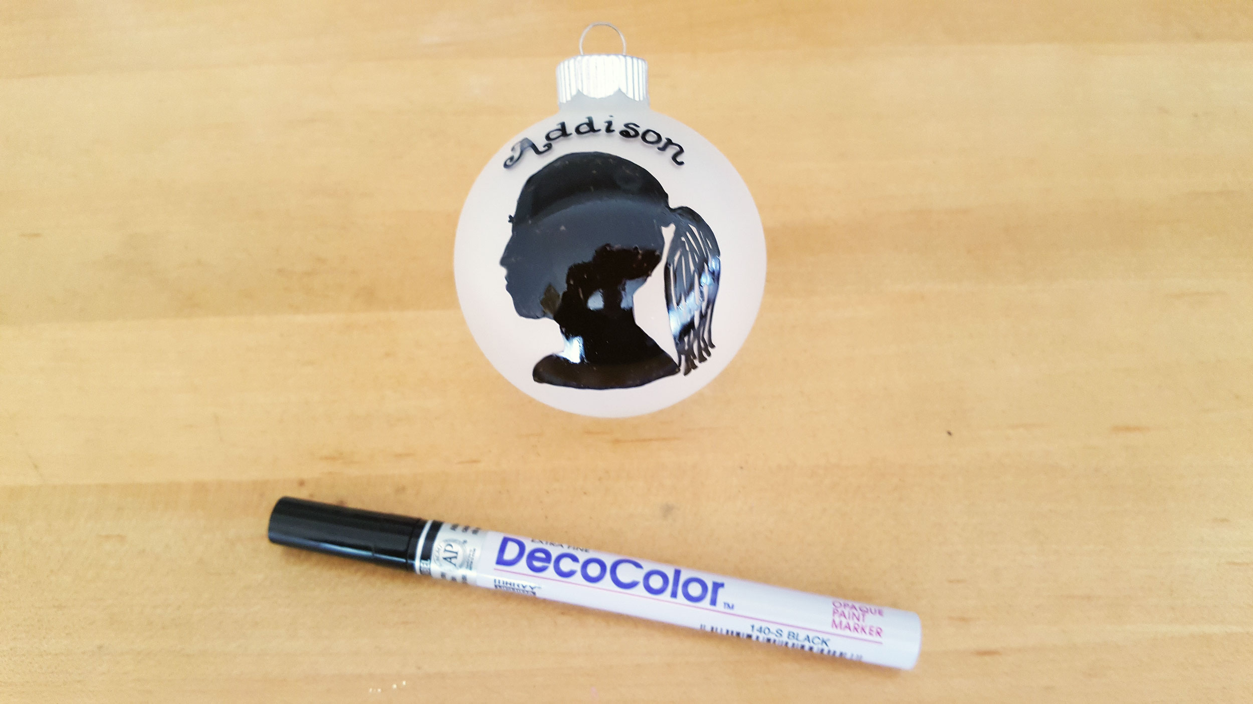 "Addison" added to frosted glass ball ornament with black marker outline filled in with DecoColor black marker. | OrnamentShop.com