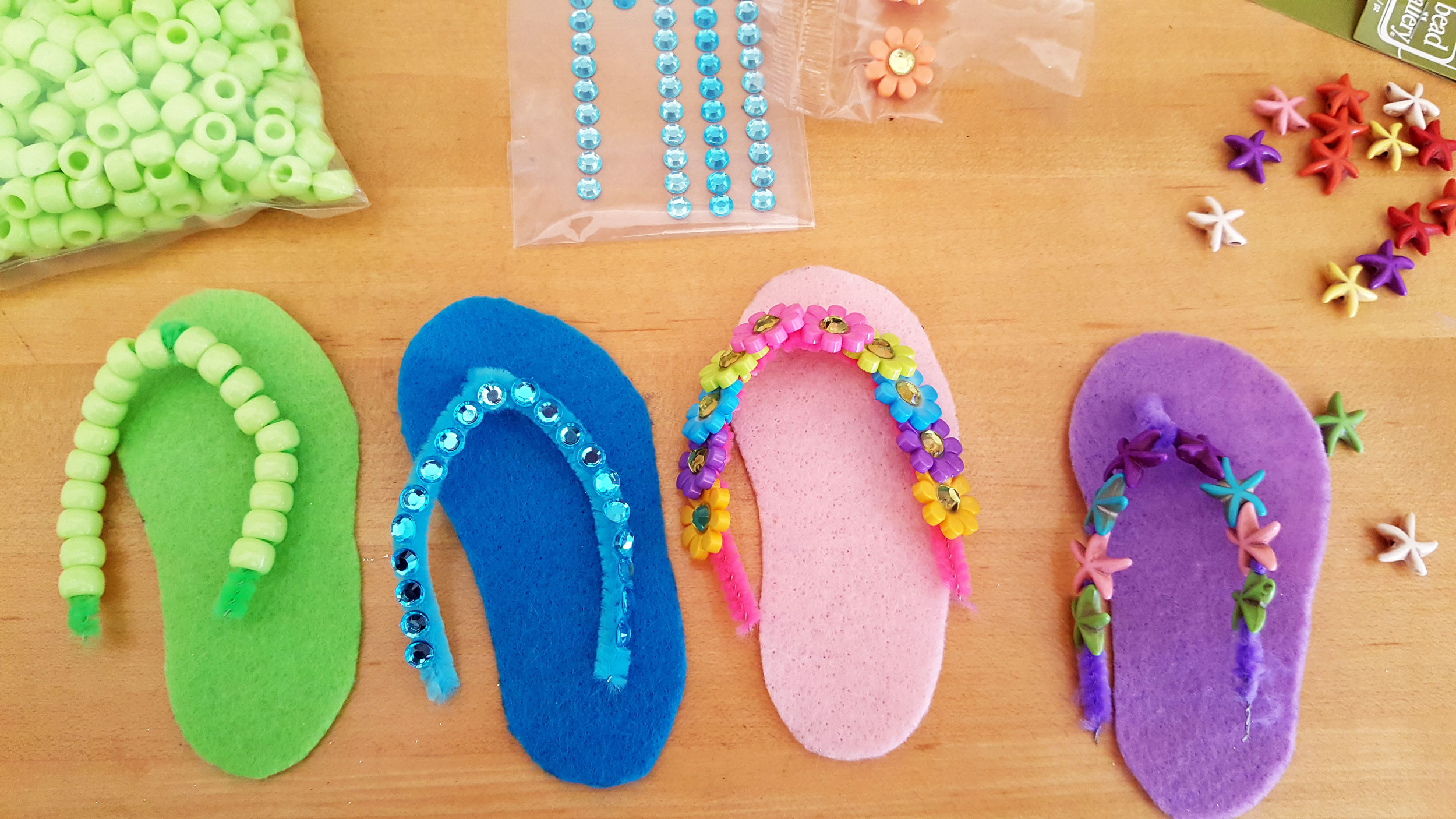 Pipe cleaners decorated with various types of pony beads. Pipe cleaners attached to felt flip flop shape. | OrnamentShop.com