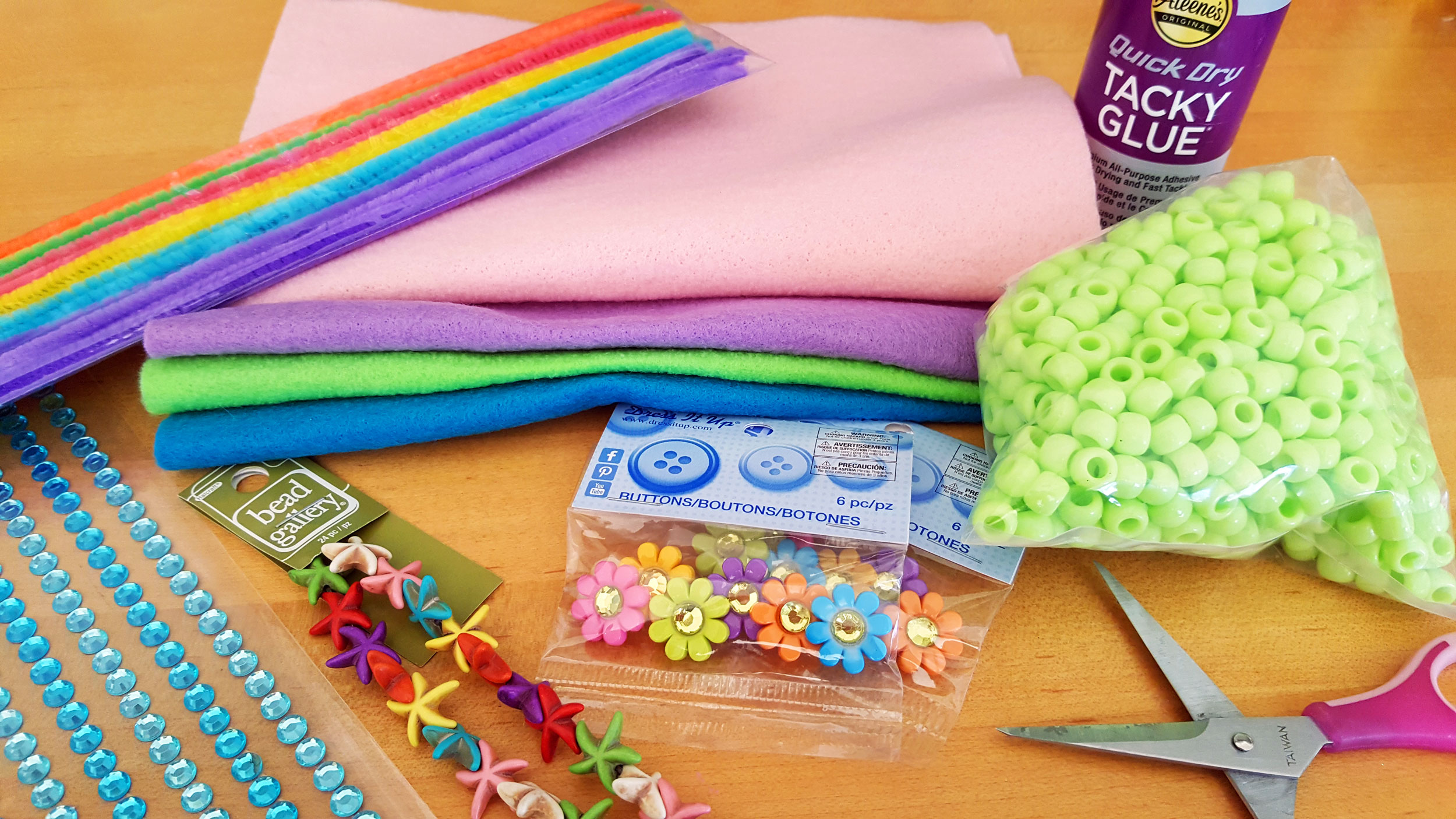 Supplies needed for craft, such as glue, beads, scissors, and felt on a table. | OrnamentShop.com