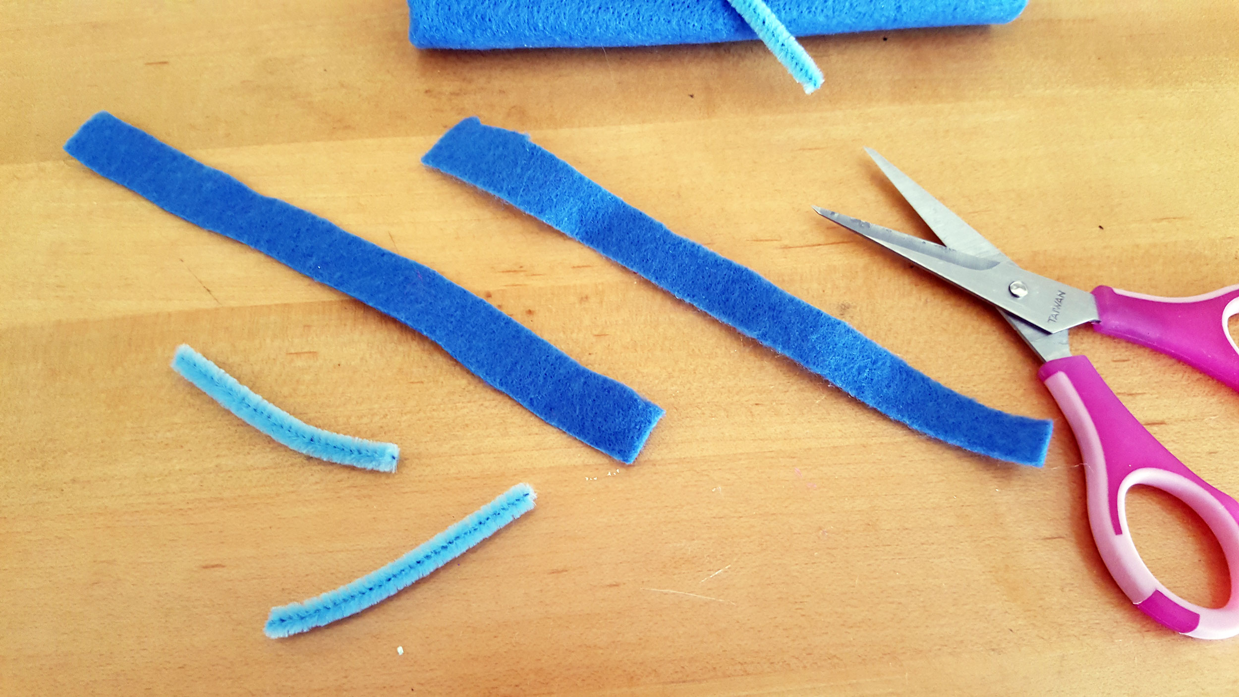 Smallfoot DIY Step 4 is to cut two small pieces of pipe cleaner and two strips of blue felt for horns. | OrnamentShop.com
