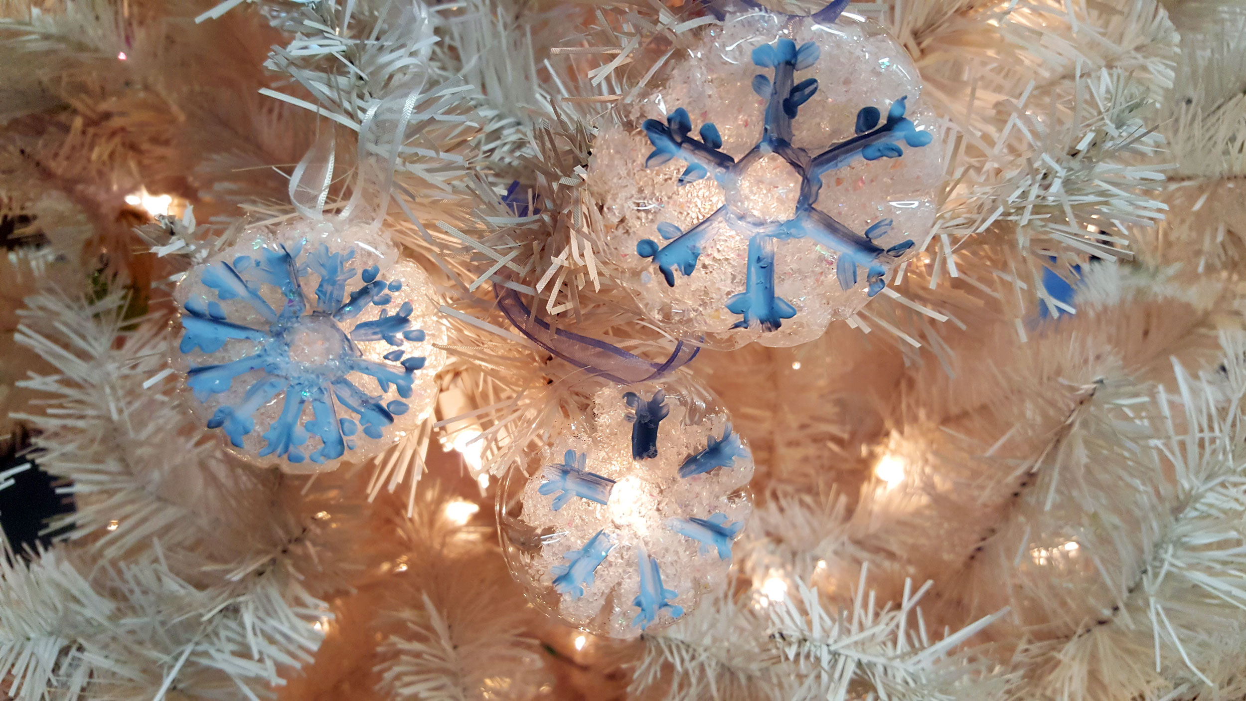 Snowflake Ornaments Lit Up On Christmas Tree | OrnamentShop.com