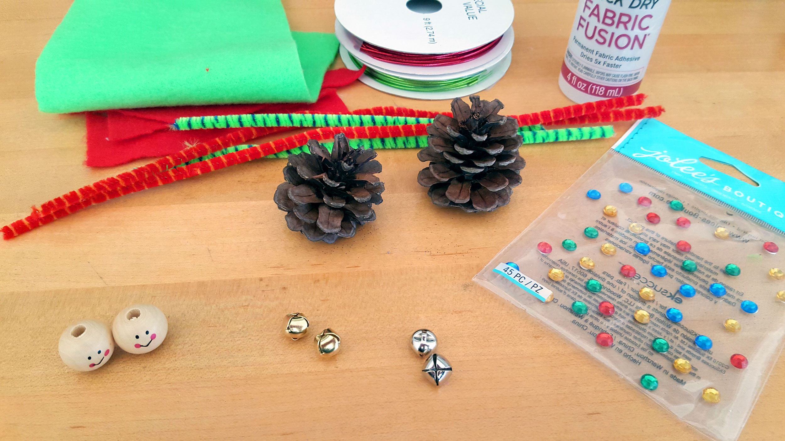 Supplies needed for DIY craft - Pine cones, felt, glue, ribbon and jingle bells. | OrnamentShop.com