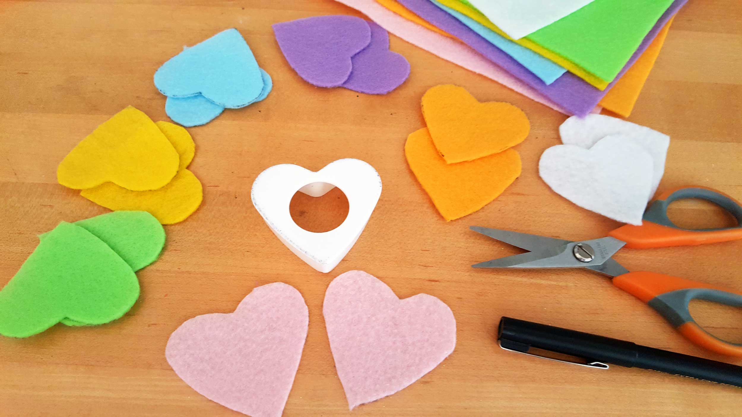 Valentine's Day ornaments DIY with Conversation Hearts step 1 is to using your heart stencil and marker, trace 2 hearts on each color of felt and cut. | OrnamentShop.com