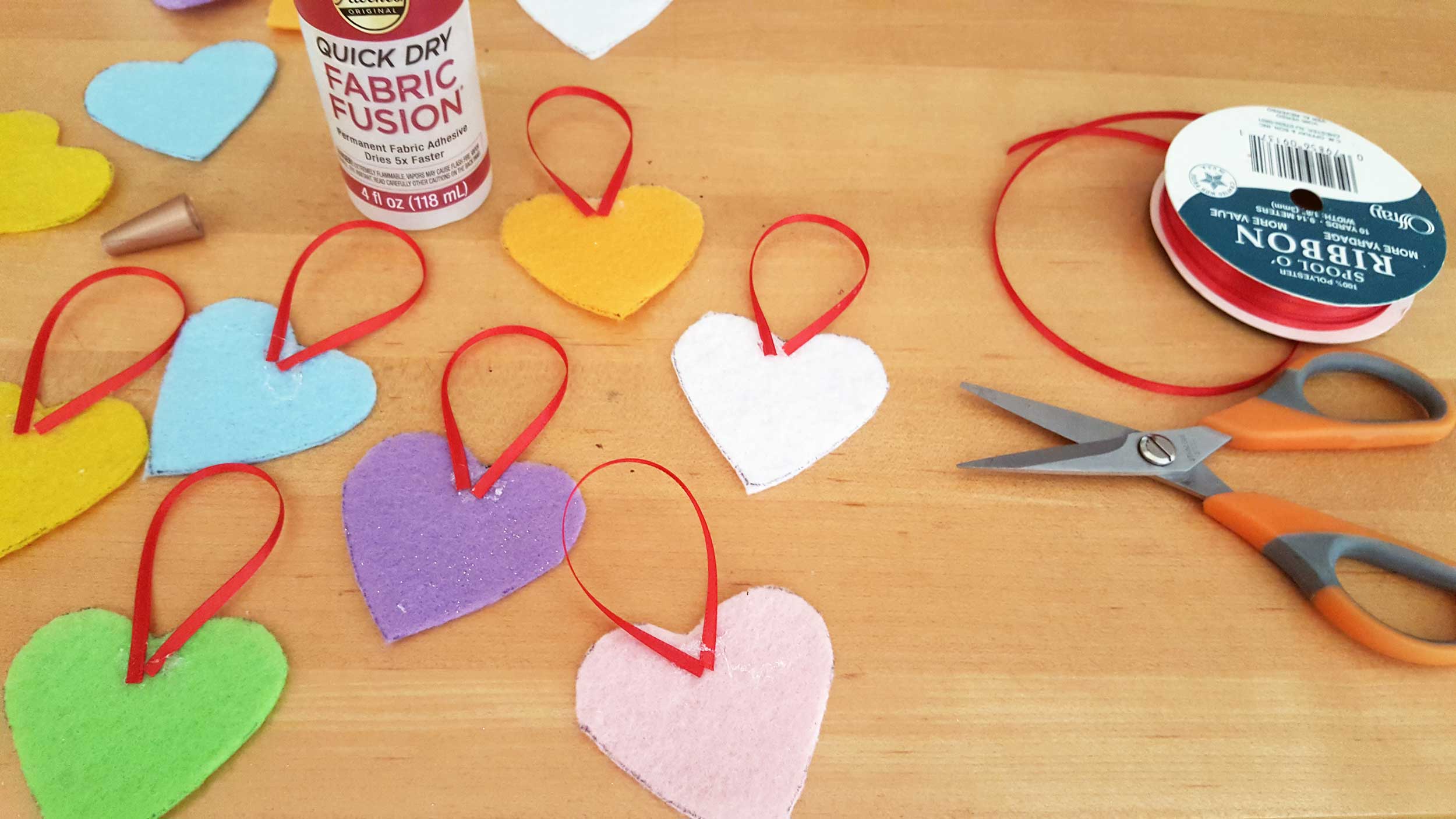 Valentine's Day ornaments DIY with Conversation Hearts step 2 is to glue ribbon on each one. | OrnamentShop.com