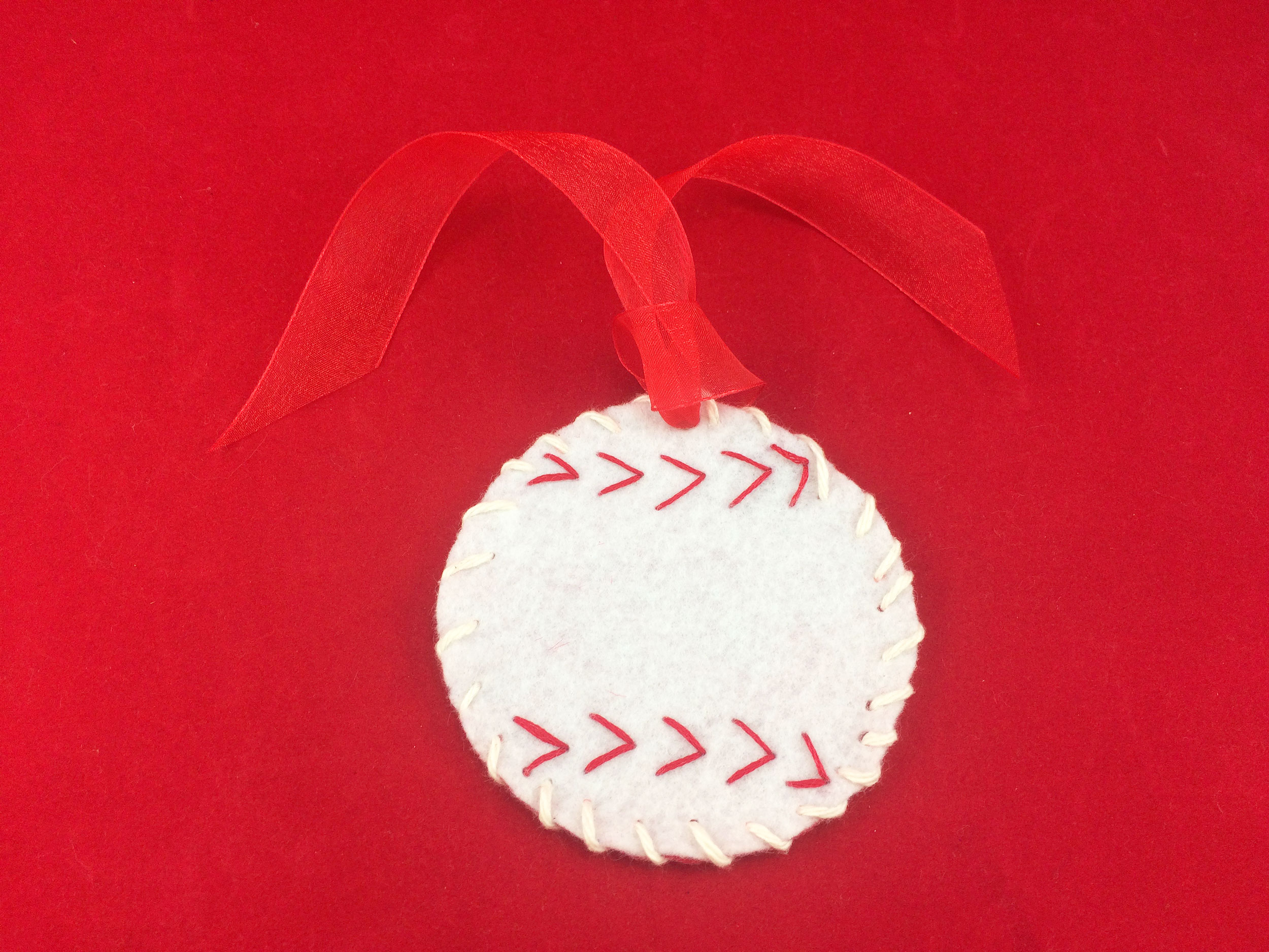 Ornament loop ribbon sewn to the top of the baseball using a needle. | OrnamentShop.com