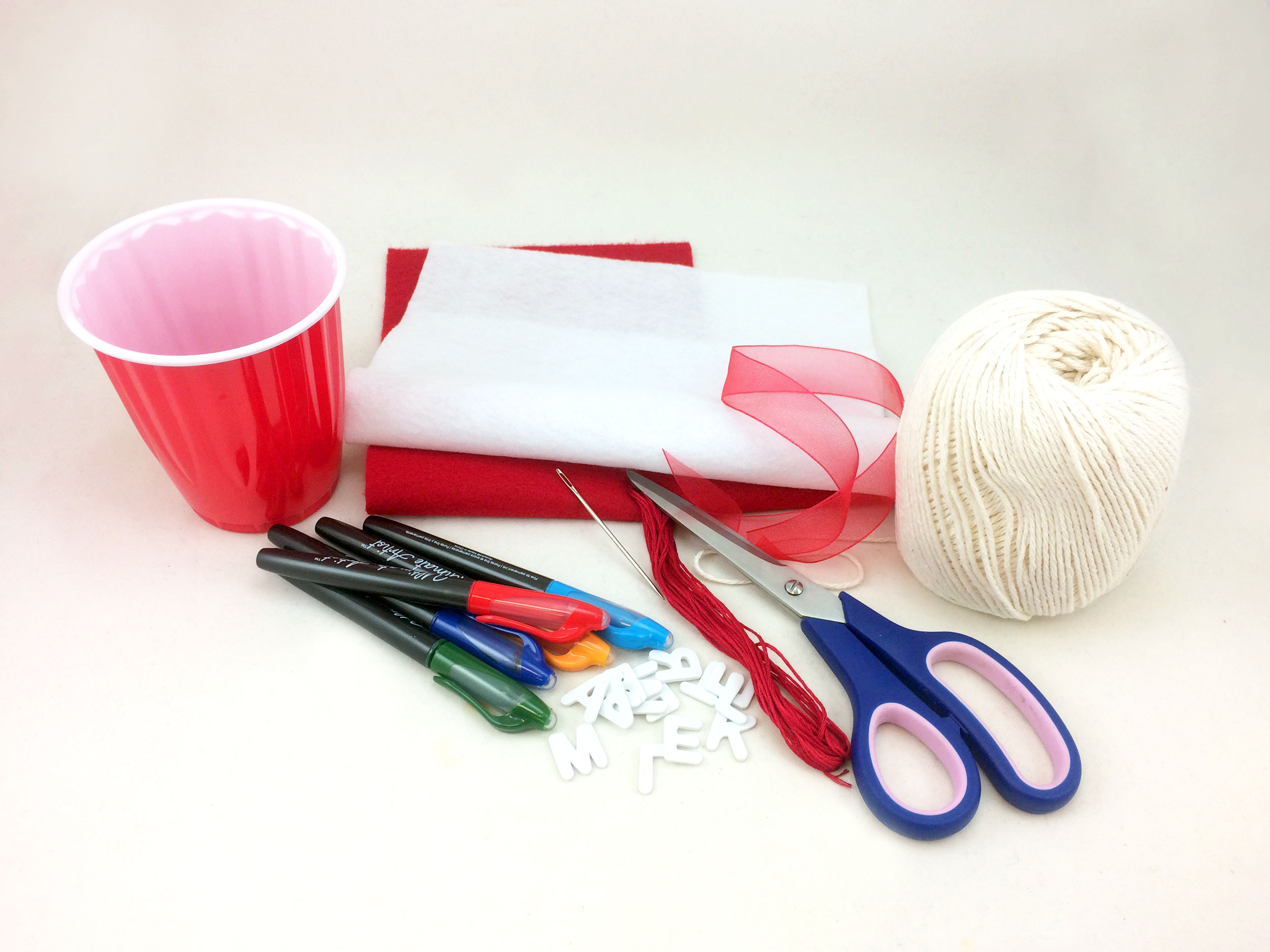 Baseball Ornament supplies on table, such as scissors, felt, markers, plastic cup, and string. | OrnamentShop.com