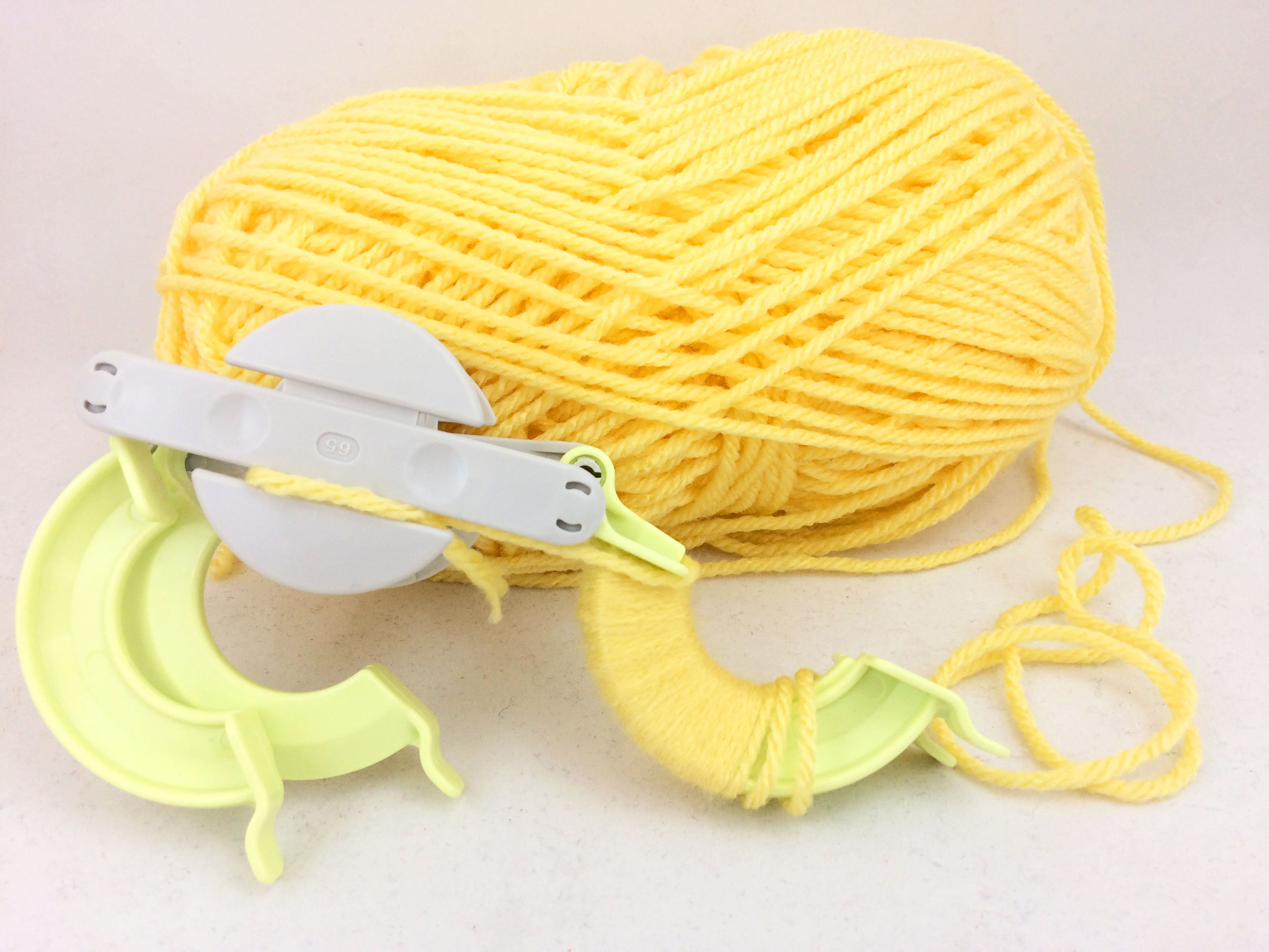 Wrap yarn around pom pom maker wings. | OrnamentShop.com