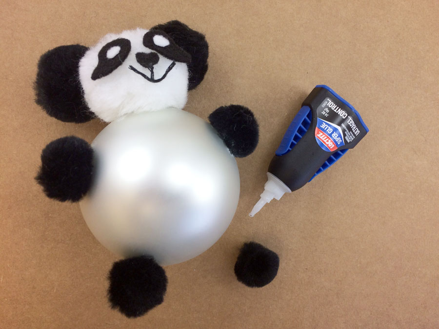 Glue black pom pom hands and feet of Panda Ornament to glass ball | OrnamentShop.com